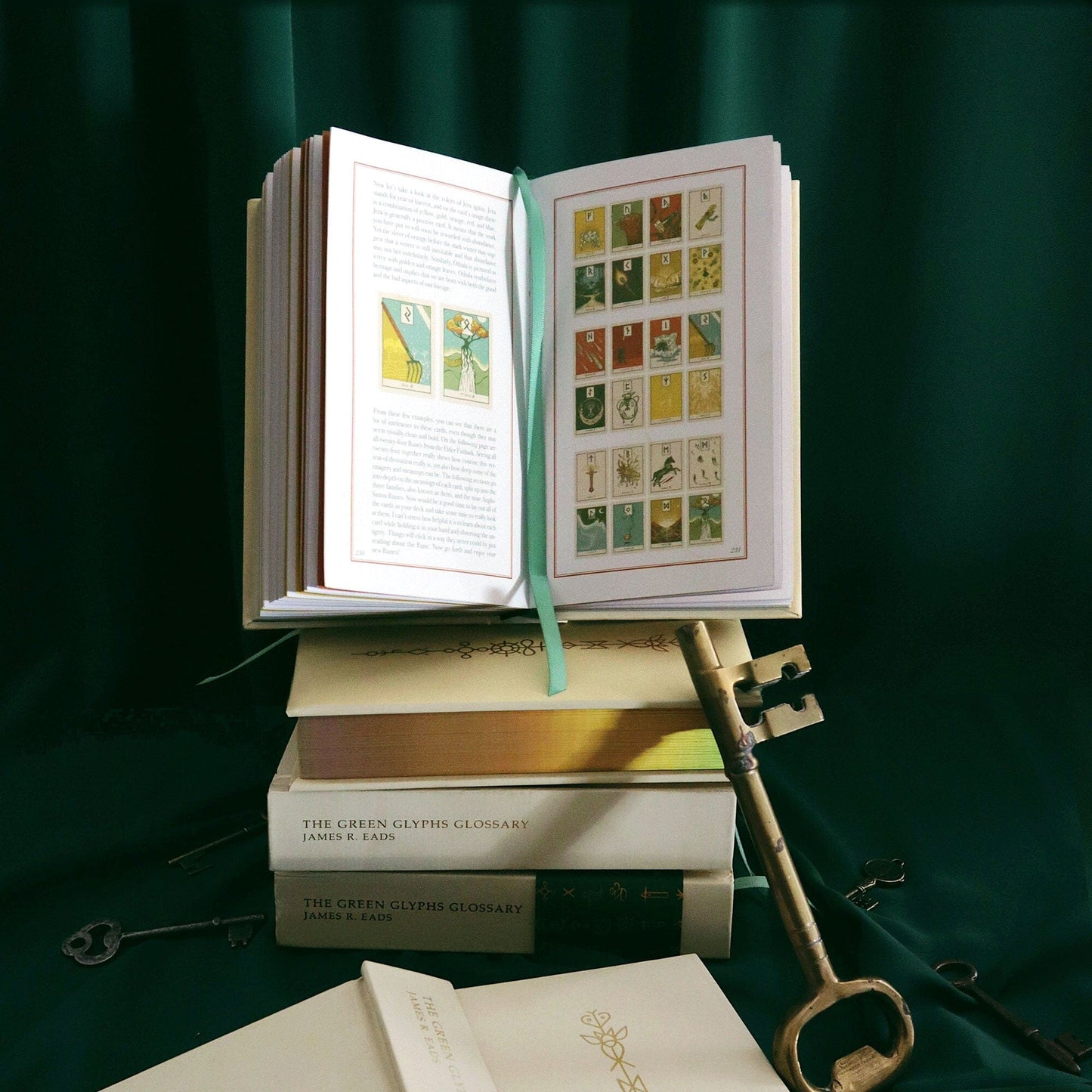 Open book with tarot card illustrations on a dark green background